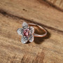 pink apatite pink sapphire brown zircon and white zircon flower cluster ring in 18k rose gold over sterling silver shown in a lifestyle photo