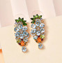chrome diopside and white zircon cluster dangle earrings in 18k yellow gold over sterling silver shown in a lifestyle photo