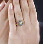sphene and multi color diamond halo ring in 18k yellow gold and black and white rhodium over sterling silver worn on a hand