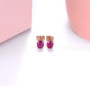 close up of untreated natural oval ruby stud earrings in 14k rose gold