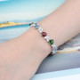 blue topaz garnet chrome diopside and white zircon bracelet in rhodium over sterling silver worn on a wrist