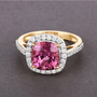 pink spinel and white diamond cushion halo ring in solid 18k yellow gold shown in a lifestyle photo
