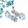 back view of sky blue topaz and zircon flower dangle earrings in rhodium over sterling silver