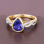 front view of bezel set pear cut tanzanite and diamond ring in 14k yellow gold