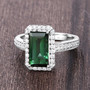 emerald cut green tourmaline and diamond halo ring in 14k white gold shown in a lifestyle photo