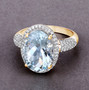 oval aquamarine and diamond halo ring in 14k yellow gold shown in a lifestyle photo