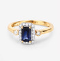 front view of emerald cut blue sapphire and white diamond halo ring in 14k yellow gold