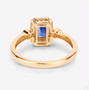 back view of emerald cut blue sapphire and white diamond halo ring in 14k yellow gold