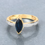 marquise cut blue sapphire and white diamond ring in 14k yellow gold shown in a lifestyle photo