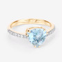 angled view of trillion aquamarine and diamond halo ring in 14k yellow gold
