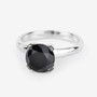 angled view of round black diamond solitaire ring in 14k white gold