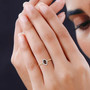 color change garnet and diamond oval halo ring in 10k yellow gold worn on a hand