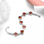 close up of sugar loaf cut hessonite garnet and white zircon tennis bracelet in rhodium over sterling silver