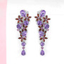 amethyst and garnet multi gemstone earrings in rhodium over sterling silver shown in a lifestyle photo