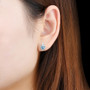 blue topaz and white zircon heart stud earrings in rhodium over sterling silver worn on the ear