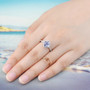 tanzanite and white zircon halo cluster ring in rhodium over sterling silver worn on a hand