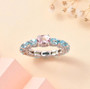 morganite blue apatite and moissanite eternity band ring in rhodium over sterling silver shown in a lifestyle photo