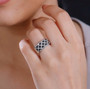 black and white diamond cluster band ring in black and white rhodium over sterling silver worn on a hand