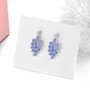 close up of tanzanite and white zircon dangle earrings in rhodium over sterling silver