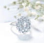 close up of aquamarine and white zircon cluster halo ring in rhodium over sterling silver