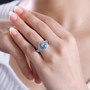 blue apatite pink sapphire and zircon halo three stone ring in 18k rose gold and rhodium over sterling silver worn on a hand