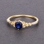 round blue sapphire and diamond ring in solid 14k yellow gold shown in a lifestyle photo