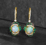ethiopian opal emerald tsavorite garnet champagne and white diamond earrings in 14k yellow gold shown in a lifestyle photo