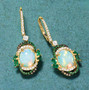 angled view of ethiopian opal emerald tsavorite garnet champagne and white diamond earrings in 14k yellow gold