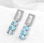 full view of sky blue topaz and white zircon dangle earrings in rhodium over sterling silver