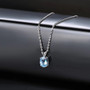 sky blue topaz oval pendant necklace in 14k white gold shown in a lifestyle photo