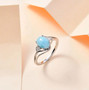larimar and moissanite three stone ring in rhodium over sterling silver shown in a lifestyle photo