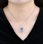 sky blue topaz and white zircon halo pendant necklace in rhodium over sterling silver worn around the neck