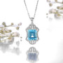 sky blue topaz and white zircon halo pendant necklace in rhodium over sterling silver shown in a lifestyle photo