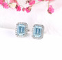 close up of aquamarine and white zircon halo earrings in rhodium over sterling silver