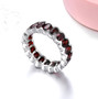 side view of oval garnet bezel set eternity band ring in rhodium over sterling silver