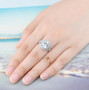 sky blue topaz and white zircon halo ring in rhodium over sterling silver worn on a hand