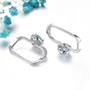 back view of heart sky blue topaz and white zircon halo hoop earrings in rhodium over sterling silver