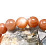 round natural peach moonstone beaded stretch bracelet 6 8 or 10mm shown in a lifestyle photo