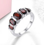 black garnet five stone band ring in rhodium over sterling silver shown in a lifestyle photo