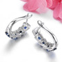 back view of blue sapphire and white zircon hoop earrings in rhodium over sterling silver
