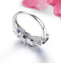 back view of blue sapphire and white zircon halo band ring in rhodium over sterling silver