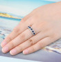 blue sapphire and white zircon halo band ring in rhodium over sterling silver worn on a hand