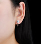 sky blue topaz and white zircon dangle earrings in rhodium over sterling silver worn on the ear