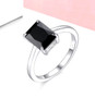 emerald cut black spinel solitaire ring in rhodium over sterling silver shown in a lifestyle photo