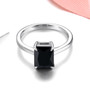 front view of emerald cut black spinel solitaire ring in rhodium over sterling silver