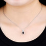 garnet and white zircon halo pendant necklace in rhodium over sterling silver worn around the neck