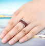 garnet and white zircon crossover band ring in rhodium over sterling silver worn on a hand