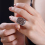 andalusite and white zircon cluster halo ring in rhodium over sterling silver worn on a hand