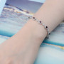garnet and white zircon halo tennis bracelet in rhodium over sterling silver