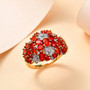 fire opal and moissanite cluster flower ring in 18k yellow gold over sterling silver shown in a lifestyle photo